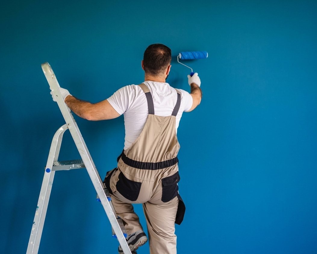 Pintor profesional de Vaciados Bilbao pintando una pared con rodillo